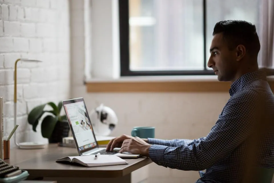 Developer working on laptop with code on screen